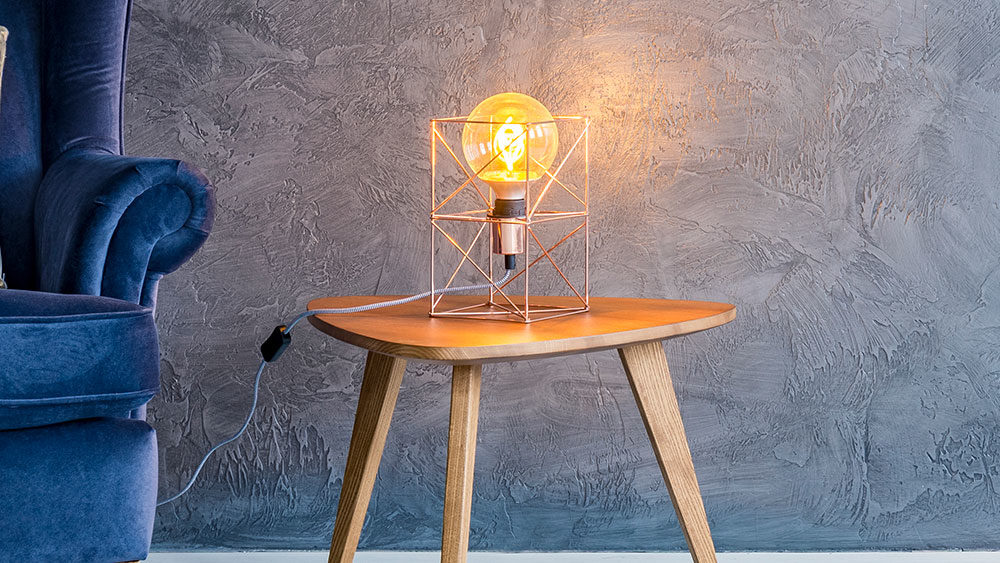 lampada da tavolo di design accesa su tavolino di legno